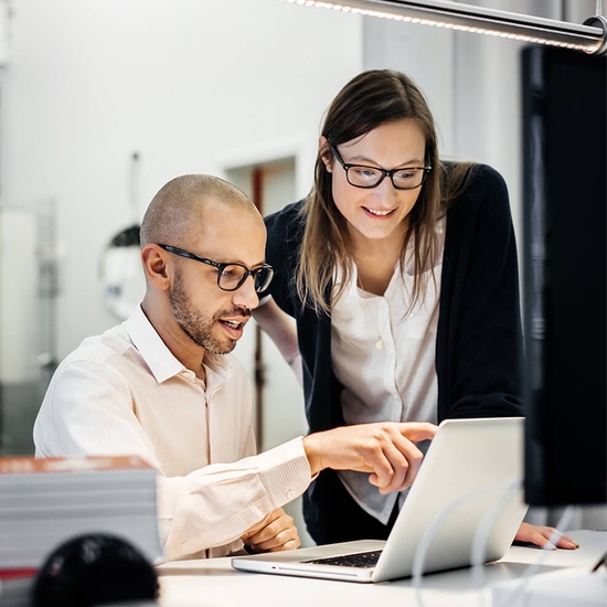 man and woman looking at computer