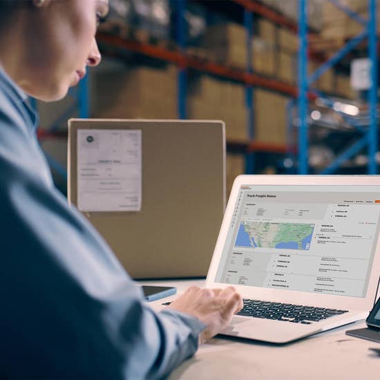 a person sitting in a warehouse looking at the load tracking screen of Schneider FreightPower
