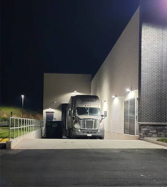 Tractor-trailer parked in loading dock at grocery store location.