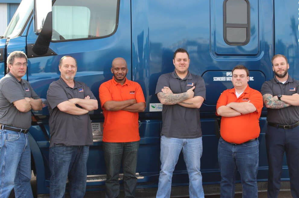 SFI employees and truck drivers stand in front of a semi-truck