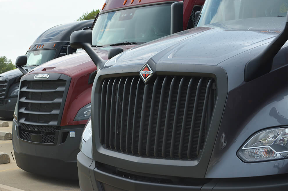 Close up of the grill of International and Freightliner semi trucks 