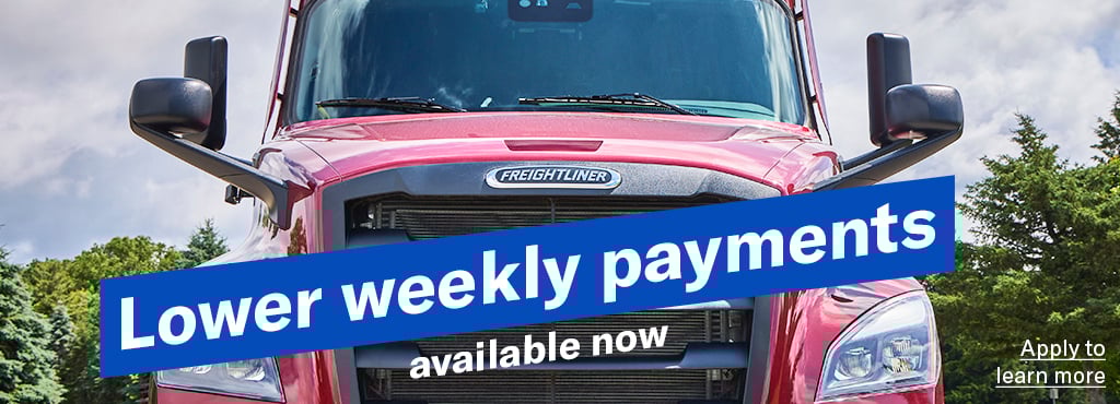 A closeup ground level shot of a red Freightliner Cascadia with the words "Lower weekly payments available now" angled across the grill and a link reading "Apply to learn more"