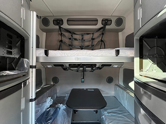 2022 Volvo bunk and dining area with two benches and a table