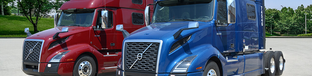 Red and blue Volvo semi trucks parked next to each other in the lot at SFI