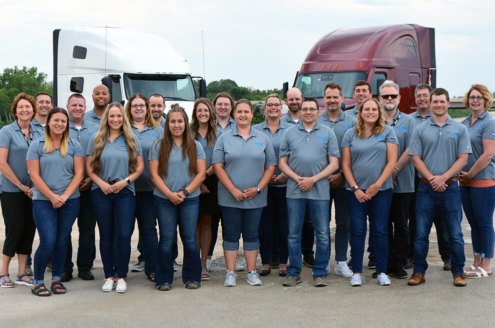 Associates from the Green Bay SFI team pose together in front of the facility's truck inventory 