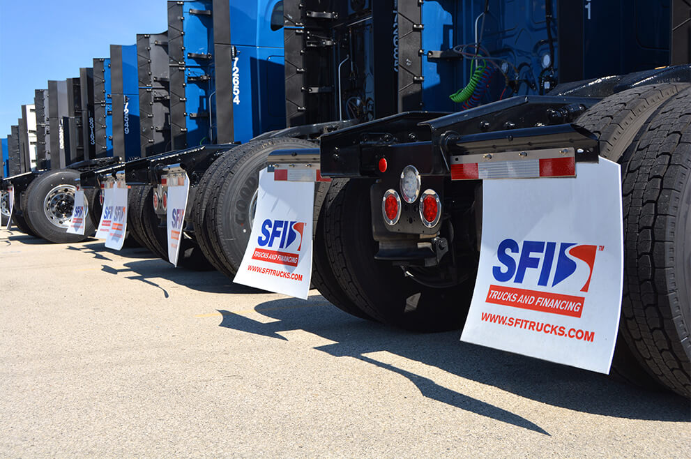 A row of semi trucks from the back side, displaying mud flaps with SFI's logo and website