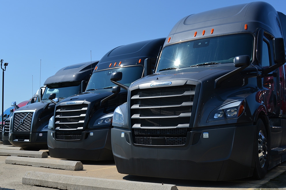 A row of Freightliner and Volvo trucks available for lease at SFI