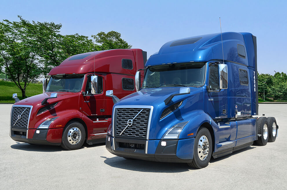 Red and blue Volvo semi trucks parked next to each other in the lot at SFI