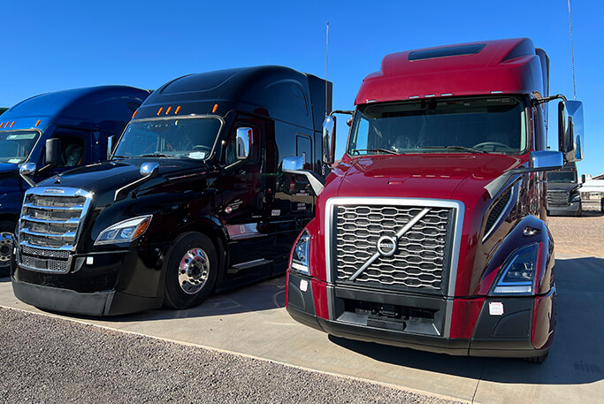 Semi-trucks available for leasing parked next to one another