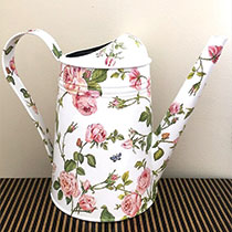 white garden watering can with pink flowers and green accents