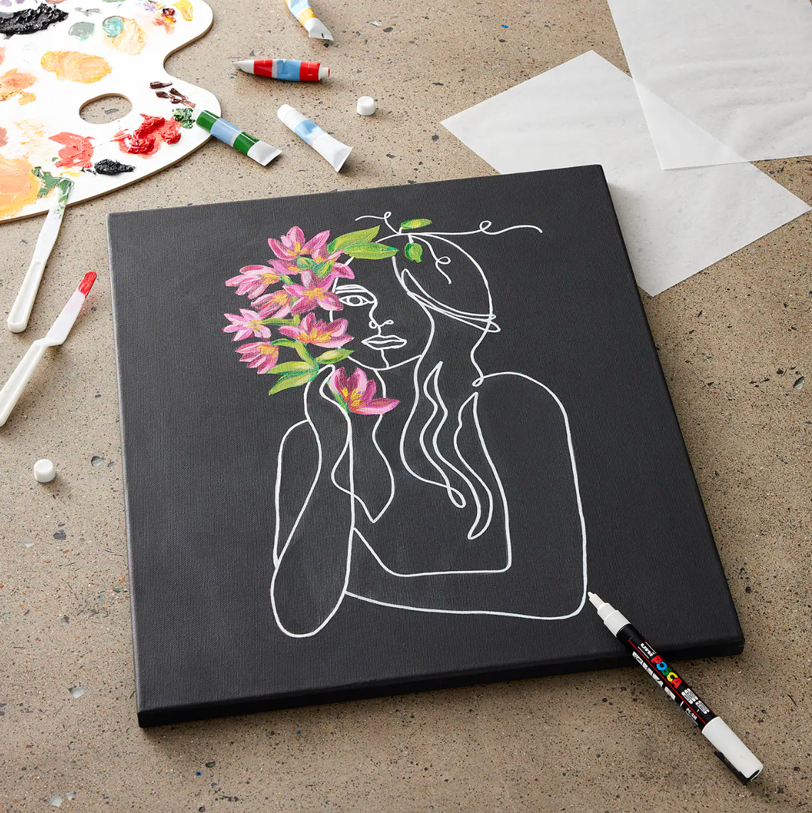 A black canvas with white outline of a figure with pink florals