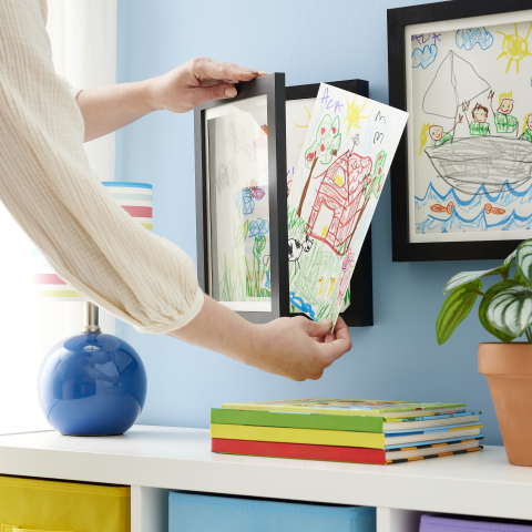 Mom loading kids art into shadow box