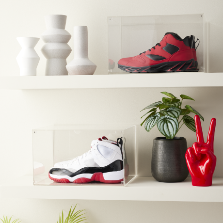 Sneakers in acrylic display cases on shelves