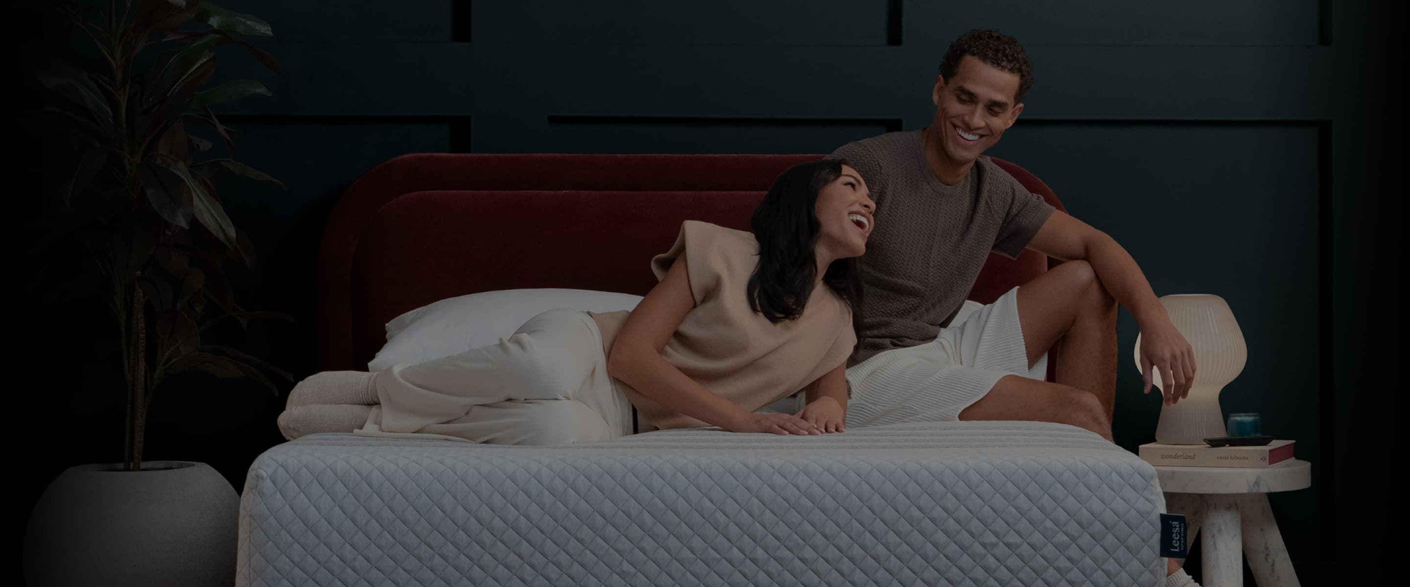 Couple looking at each other while laying on a mattress