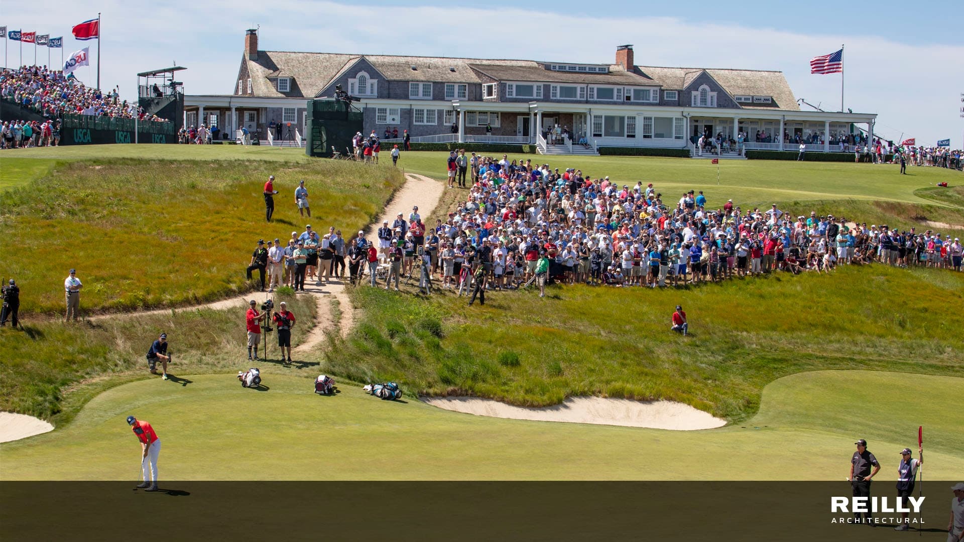 a group of people watching a golf game in front of a coastal hampton clubhouse