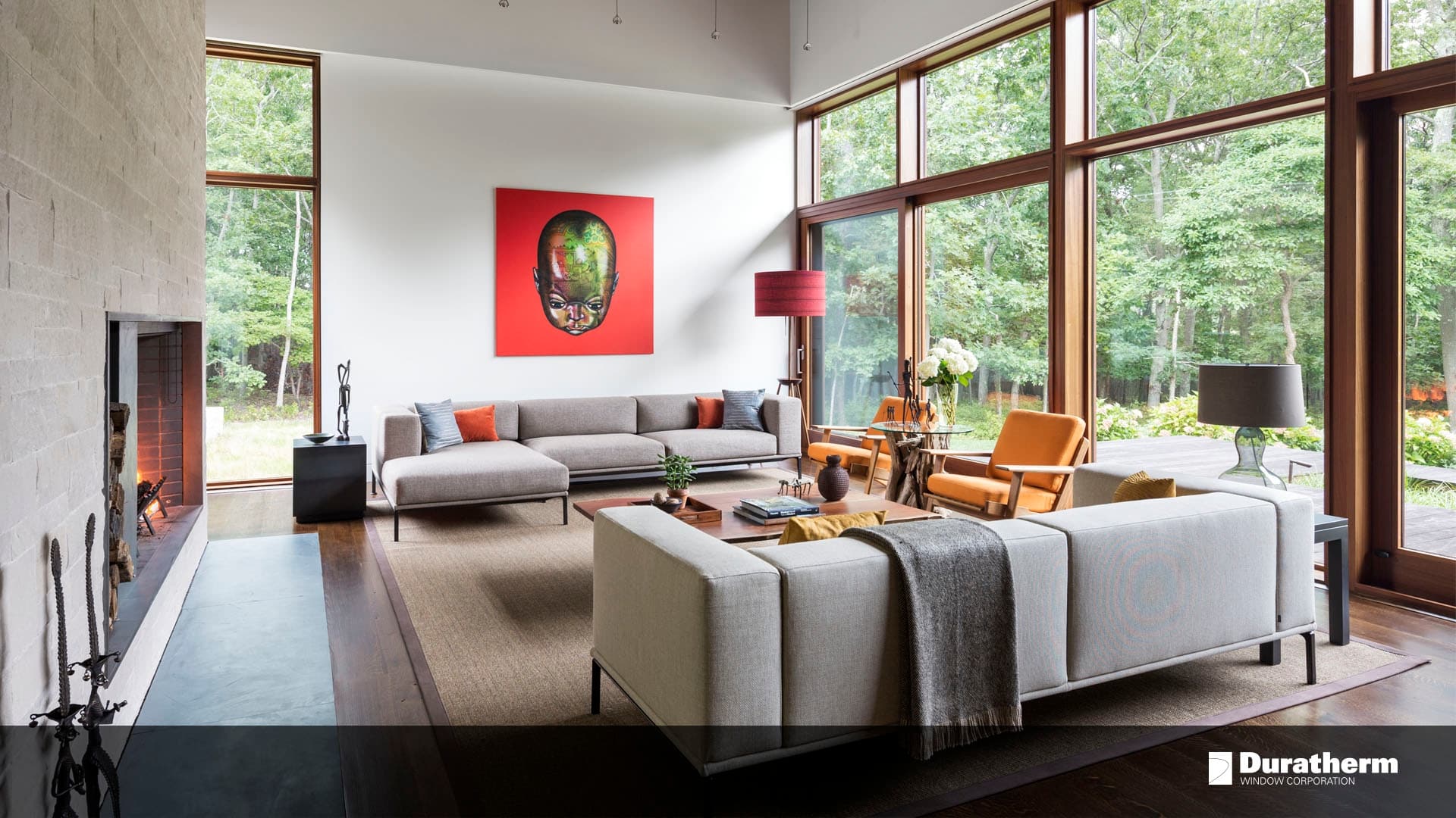 window-walled living room with a large piece of art above the couch