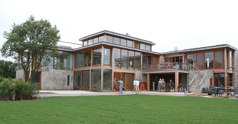 the exterior of a new contemporary home with floor-to-ceiling windows and doors