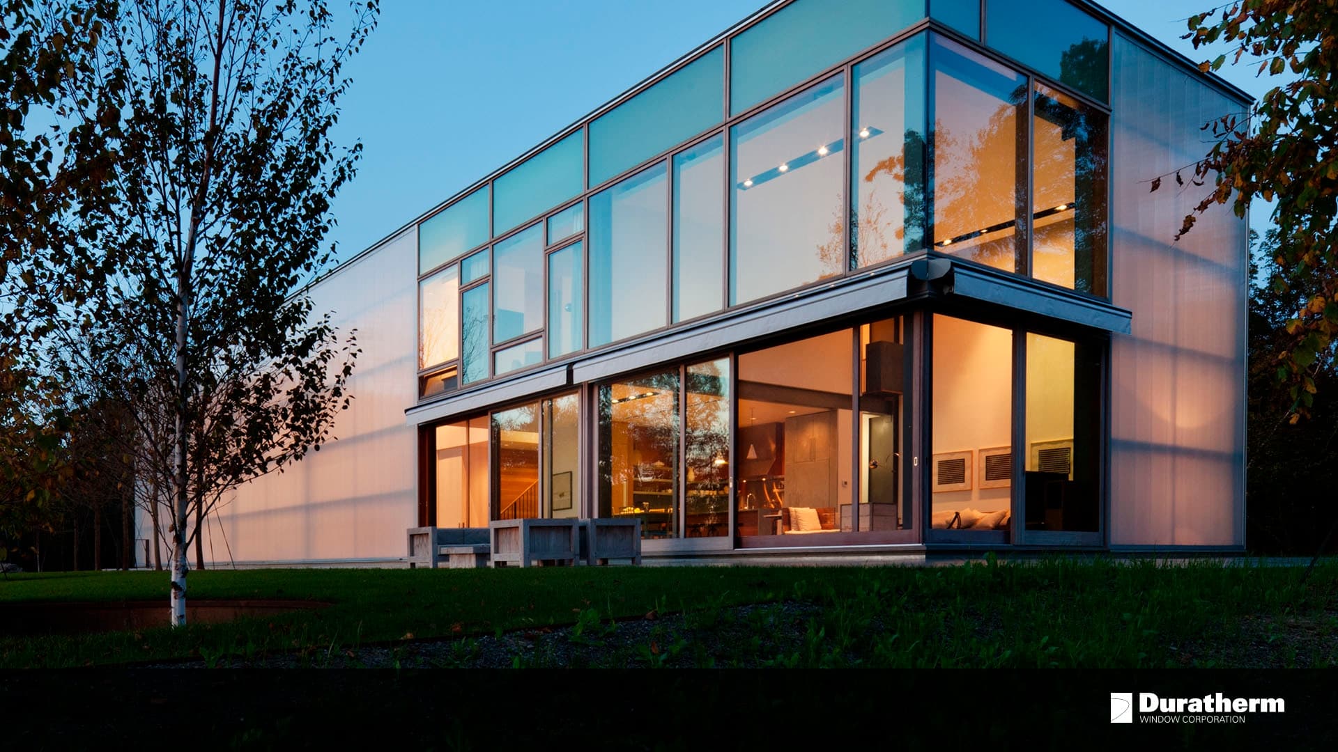 contemporary home with floor-to-ceiling windows at dusk