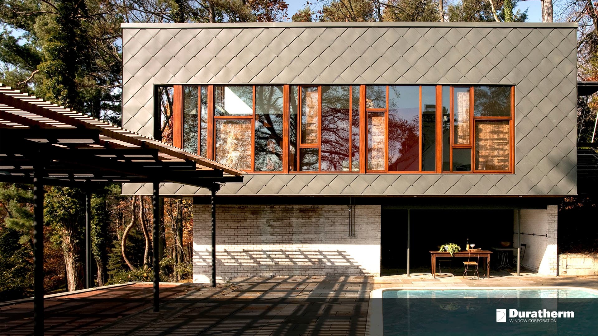 contemporary home with custom gray siding and a row of mulled wood windows