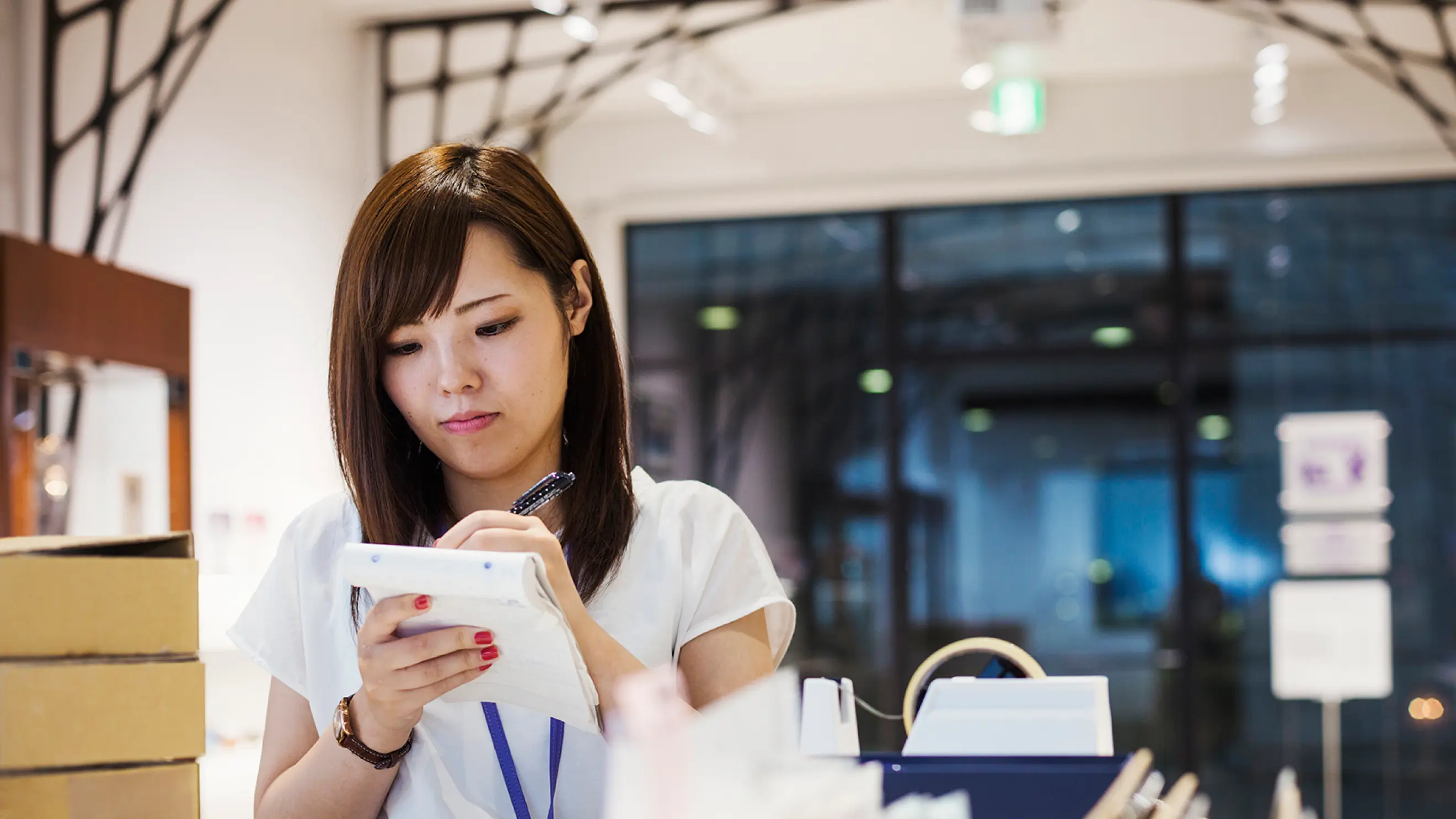 A retail employee takes inventory of products in a small shop before opening