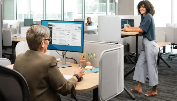 Two co-workers make conversation during work at their office