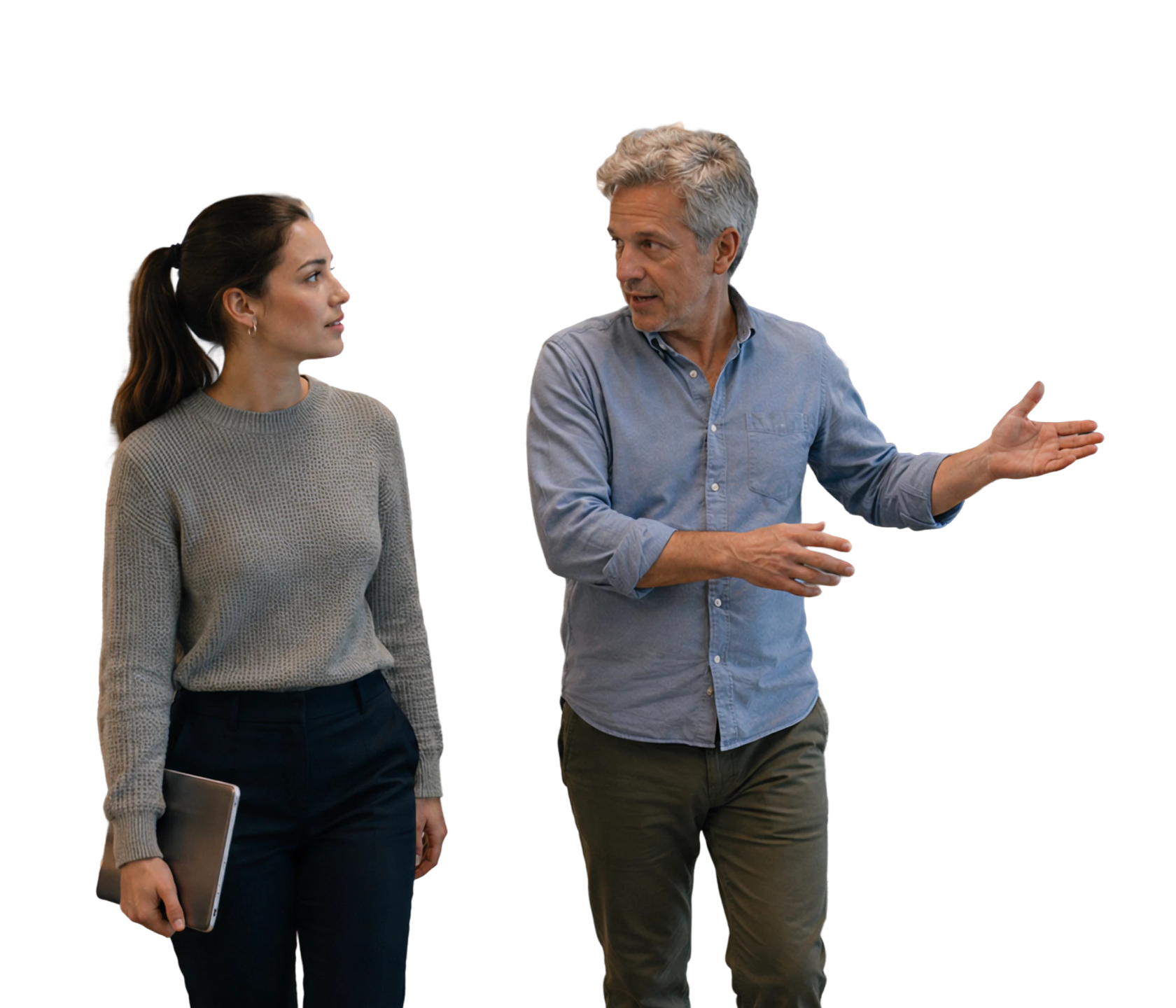 Two coworkers walking and talking in a modern office hallway.