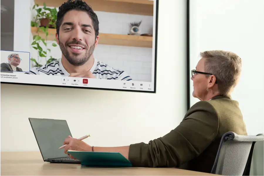 a woman with short gray hair and glasses holds a video interview with Indeed Hiring Events