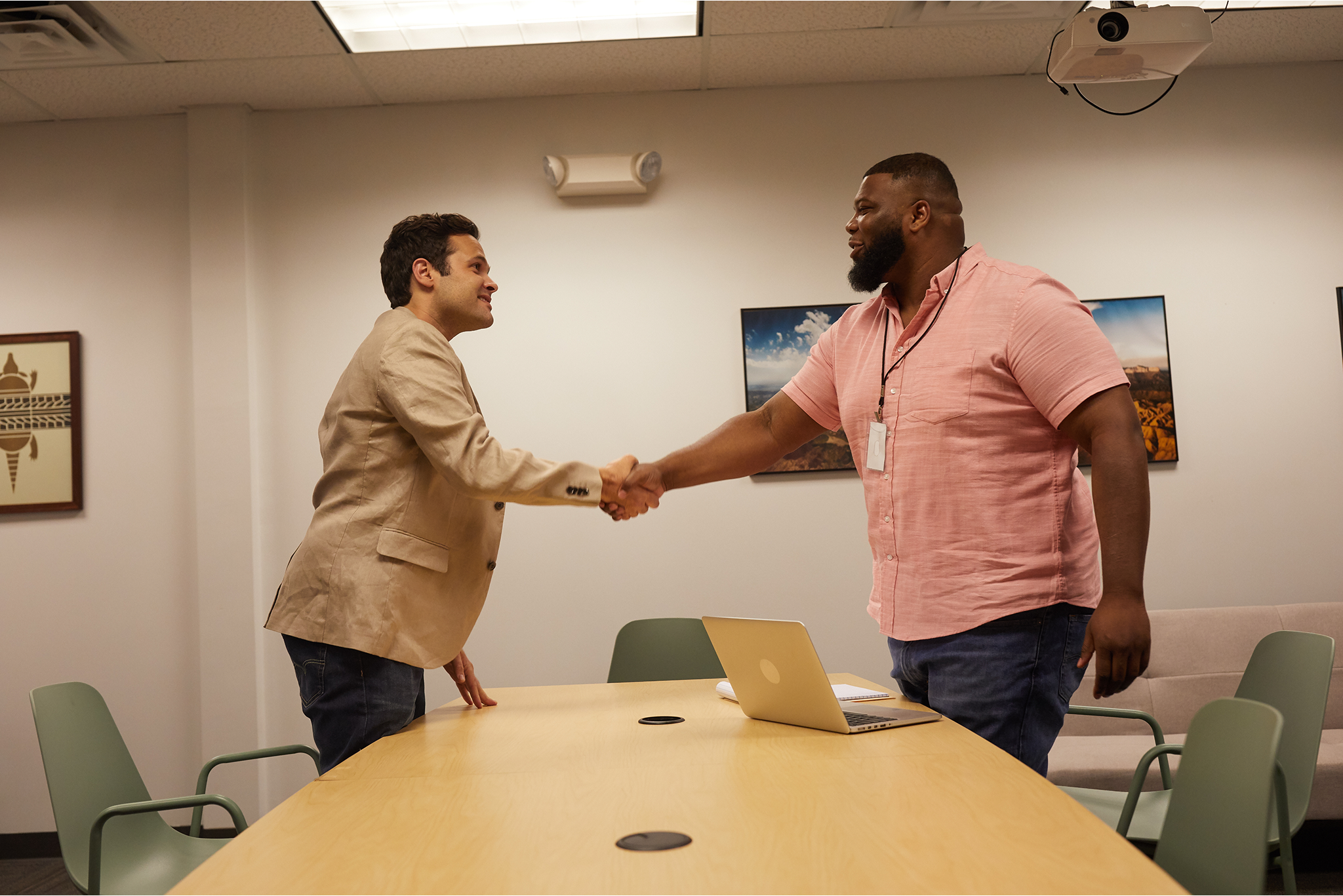 Two men in an office setting shaking hands