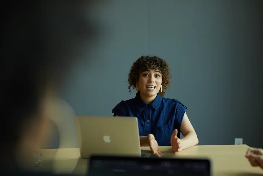 the woman sits across from a coworker and describes the features and benefits of Sponsored Jobs