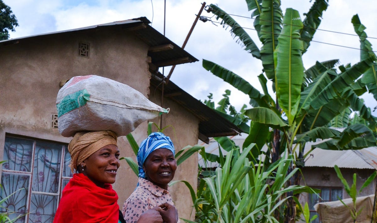 Two African women carrying bags and talking 