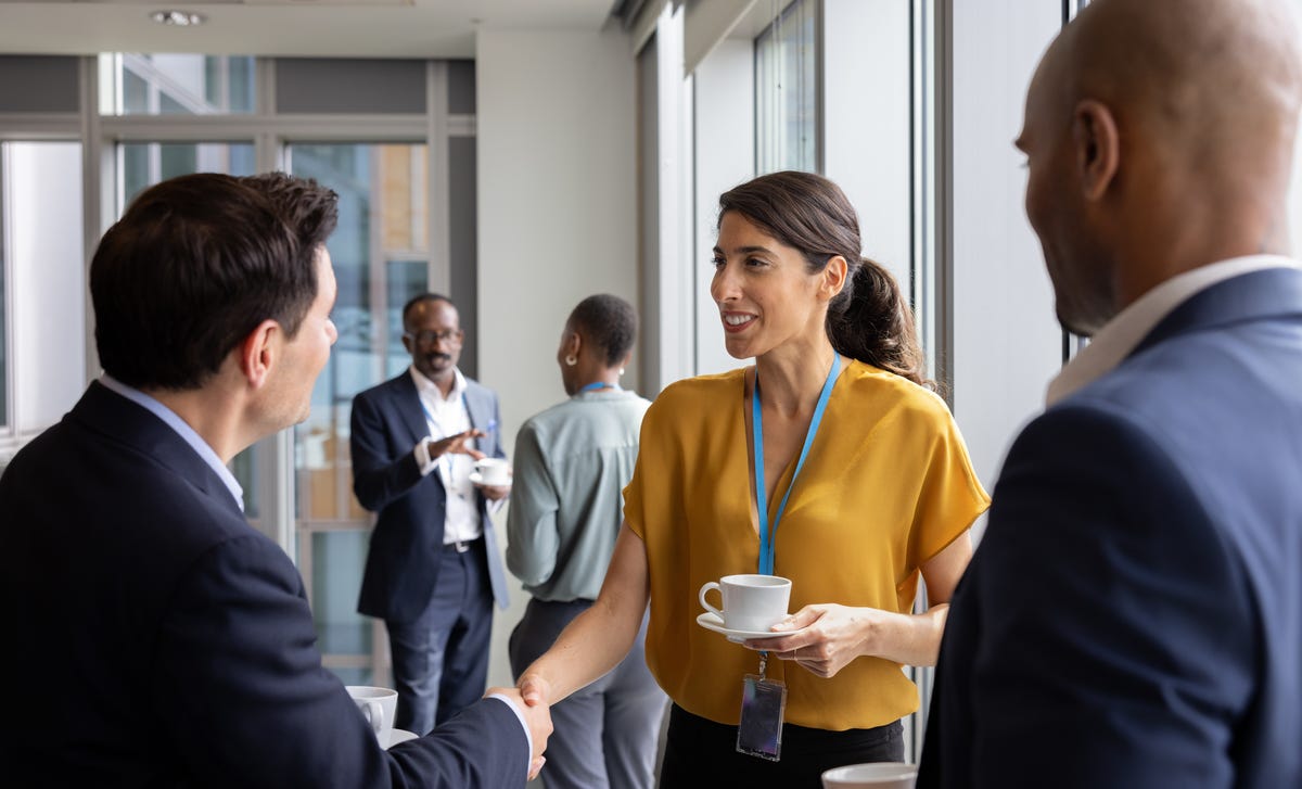 Femme d'affaires serrant la main de ses clients et discutant avec eux après avoir suivi un formation management interculturel avec Berlitz France.