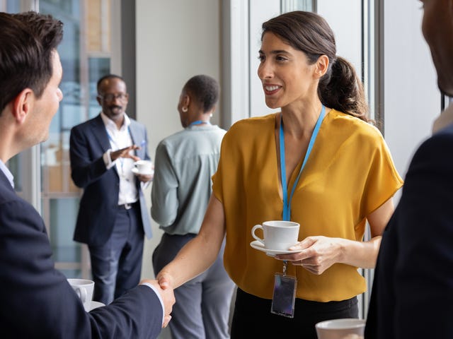Femme d'affaires serrant la main de ses clients et discutant avec eux après avoir suivi un formation management interculturel avec Berlitz France.