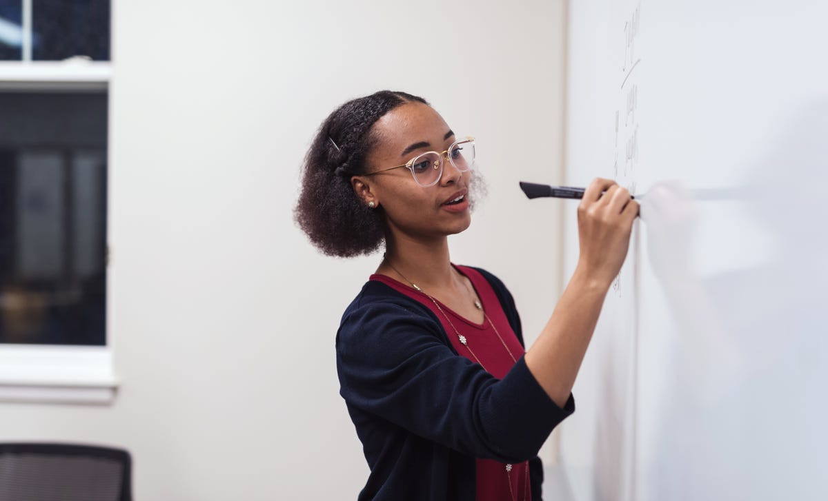 Enseignant écrivant sur un tableau blanc lors d'un cours de langue
