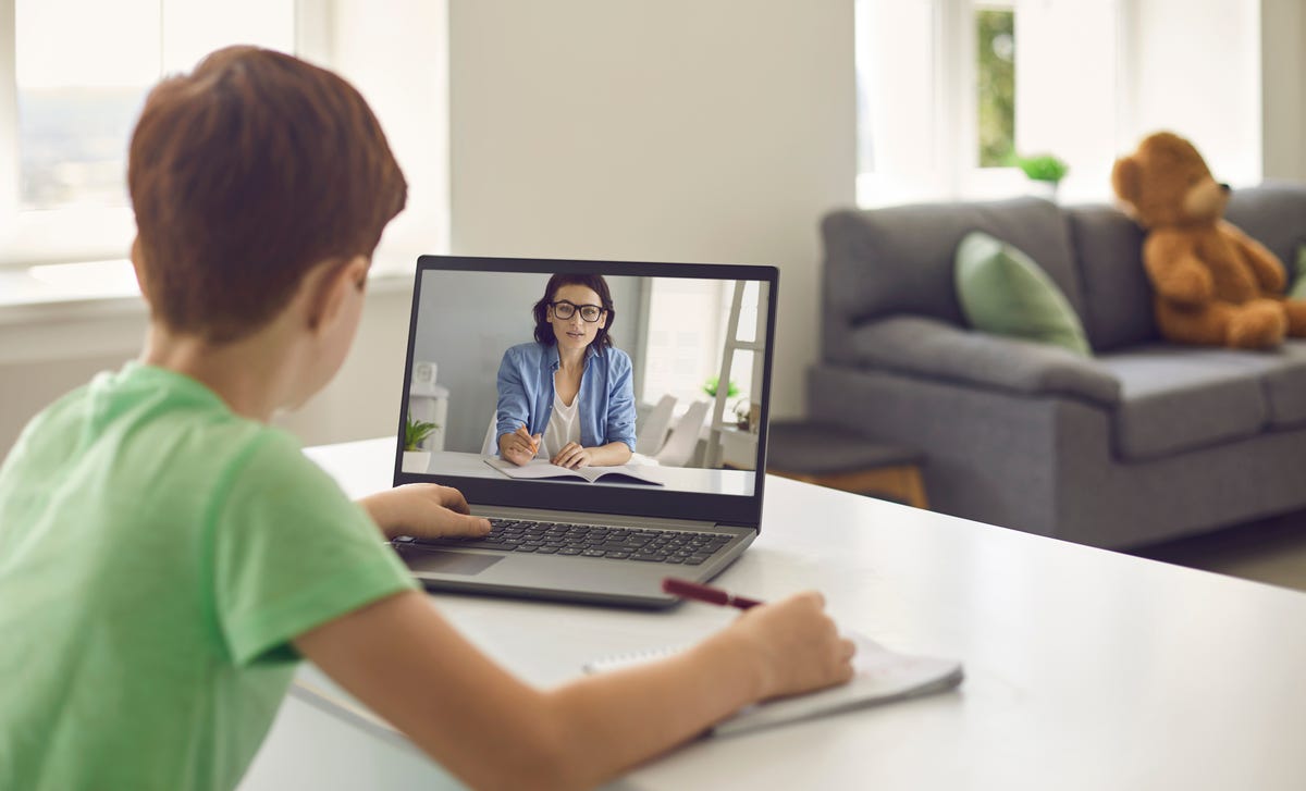 Enfant assis devant un ordinateur portable et participant à un cours de langue privé en ligne pour enfants et adolescents avec Berlitz France