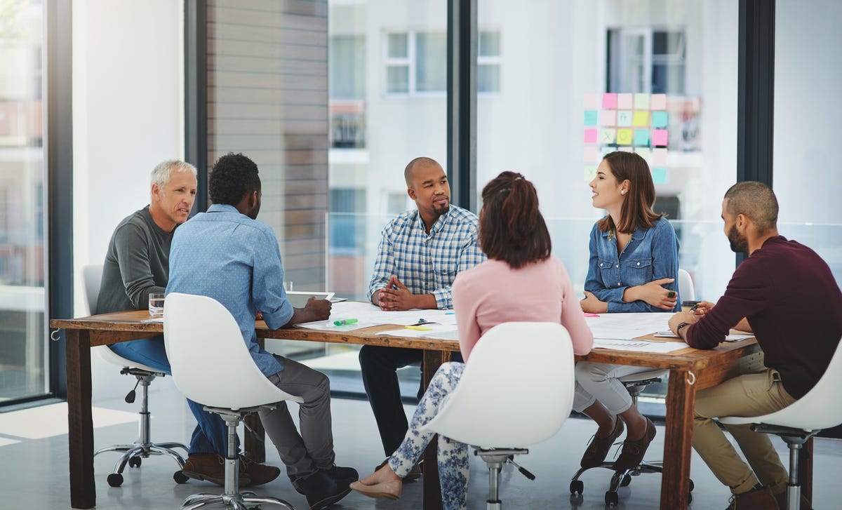 Des employés assis autour d'une table et discutant entre eux lors d'une formation expatriation avec Berlitz France