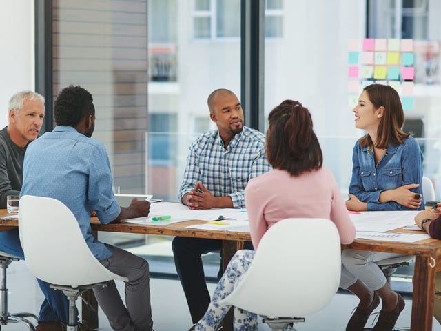 Des employés assis autour d'une table et discutant entre eux lors d'une formation expatriation avec Berlitz France