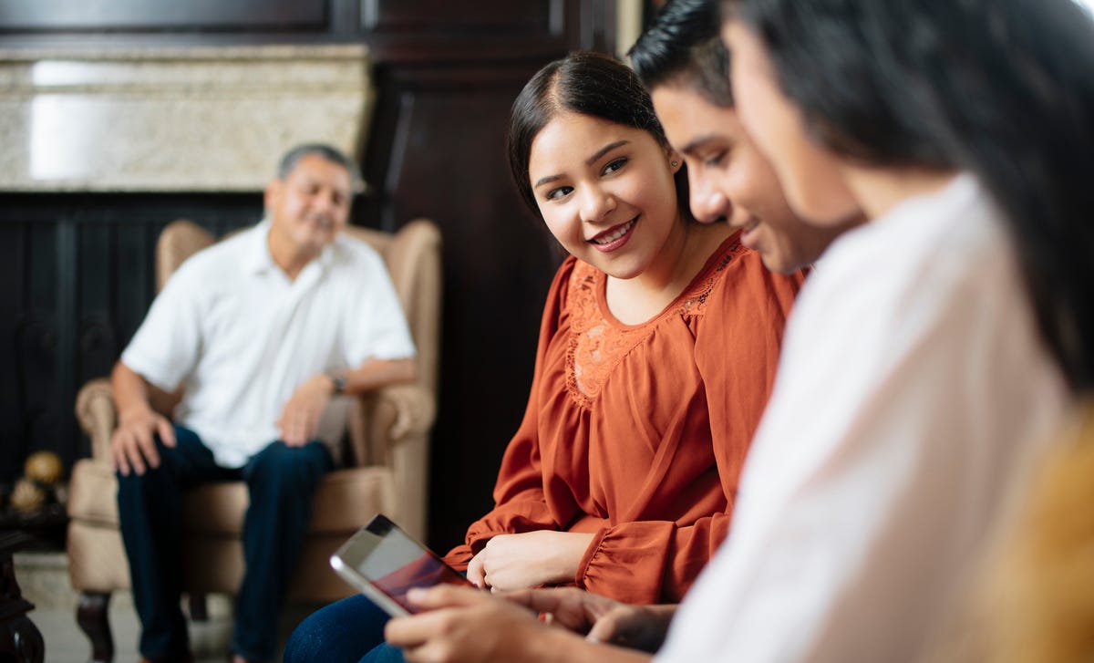 Des étudiants assis l'un à côté de l'autre regardent une tablette et discutent après leur cours d'anglais á Marseille.