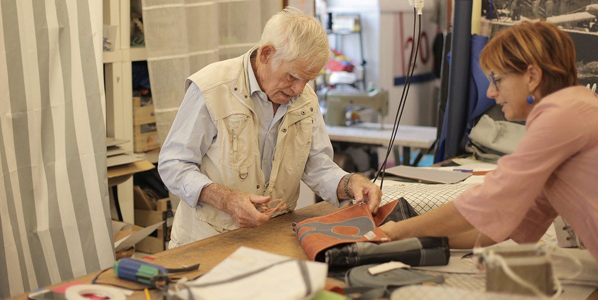 Elderly man examining the exceptional quality of textiles in a shop