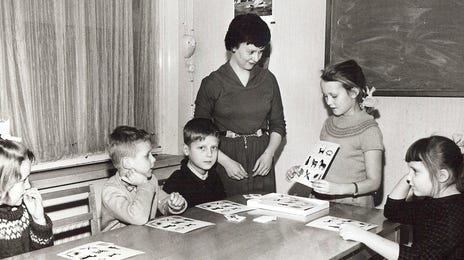 Old photograph of an instructor and her the children she teaches languages to with the Berlitz Method