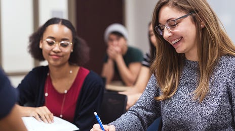 Groupe d'élèves en classe écrivant et apprenant des langues avec Berlitz après s'être renseignés sur les Berlitz prix