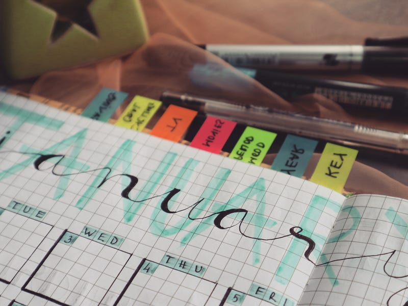 Un semainier décoré avec des notes autocollantes indiquant les jours de la semaine en anglais