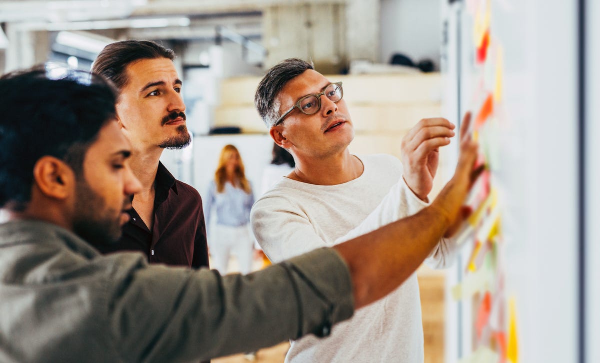 Des étudiants regardent ensemble des post-it sur un tableau blanc lors d'un cours de russe avec Berlitz France.