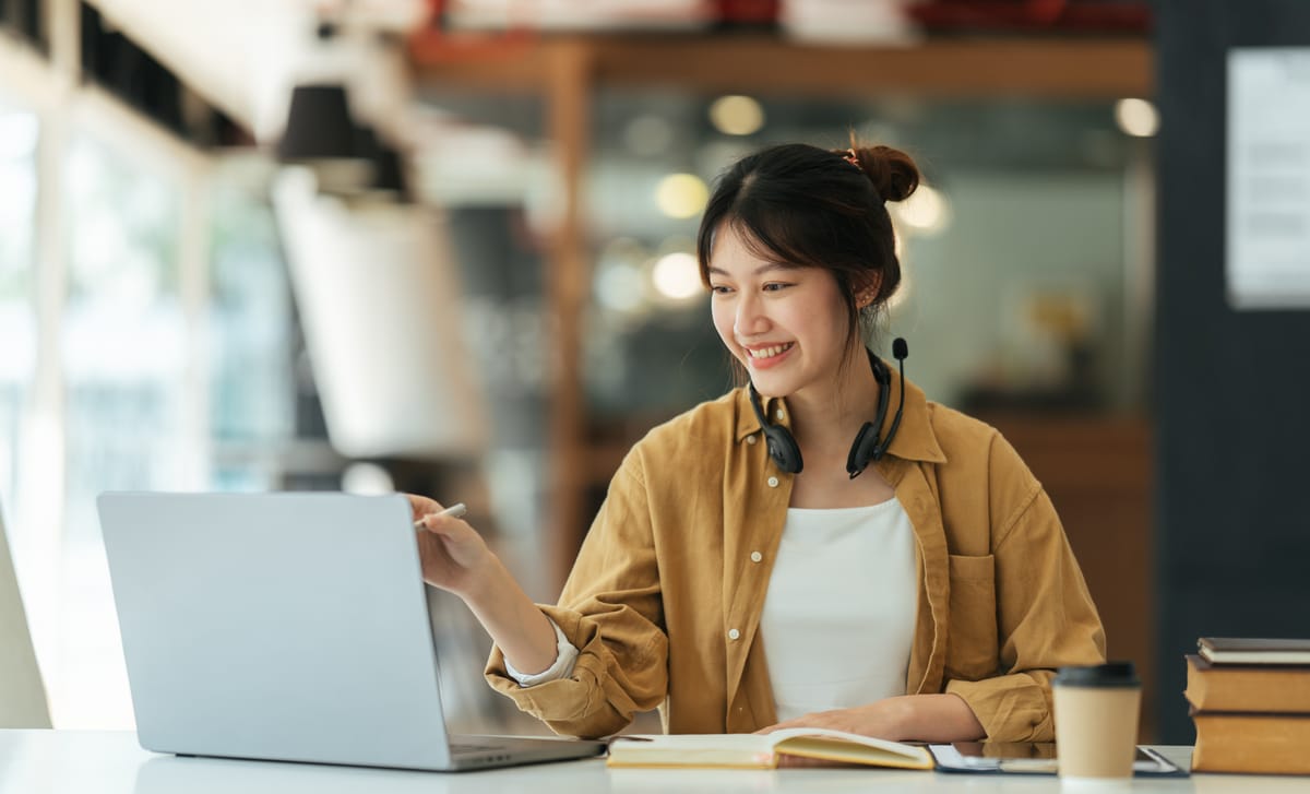 Woman learning a language with Berlitz's AI tools on her laptop