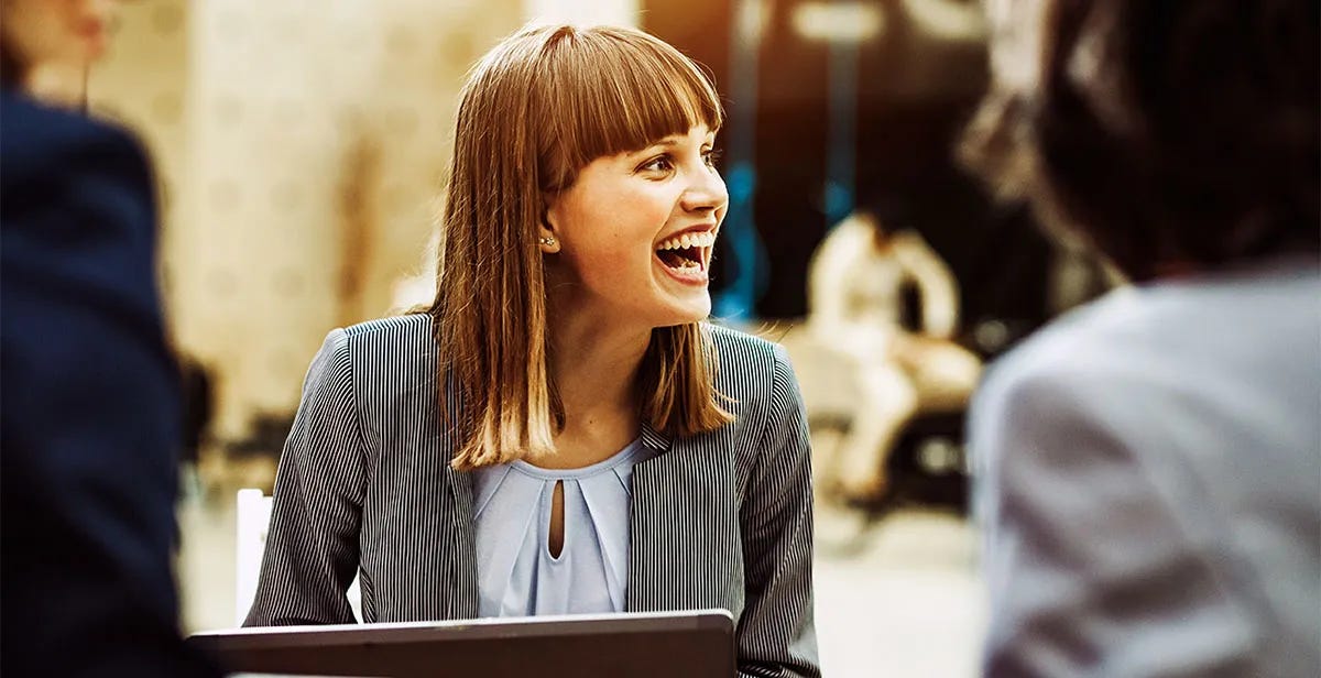 Woman chatting with her colleagues outside after composing a letter in English on her laptop