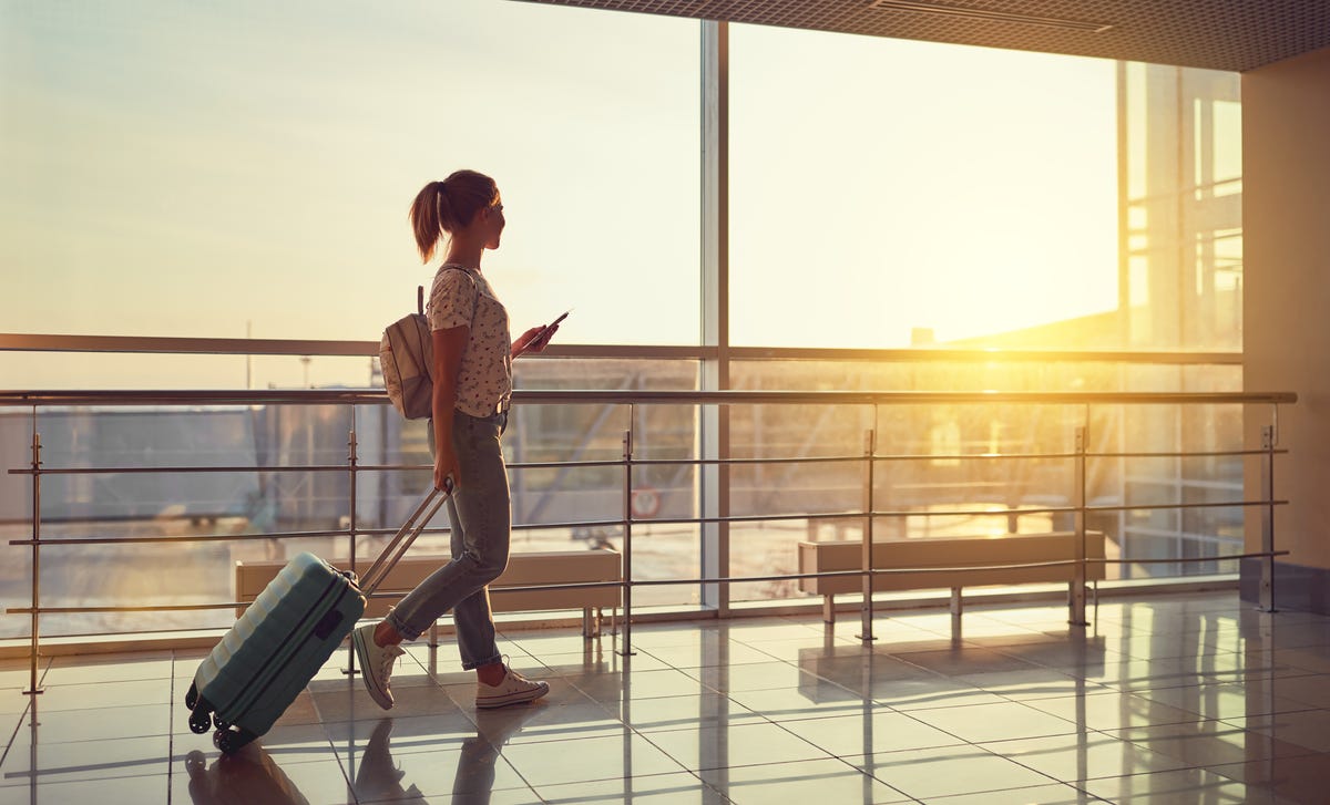 Femme avec ses bagages en route vers un avion pour apprendre une langue à l'étranger