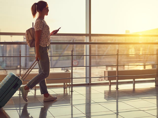 Femme avec ses bagages en route vers un avion pour apprendre une langue à l'étranger