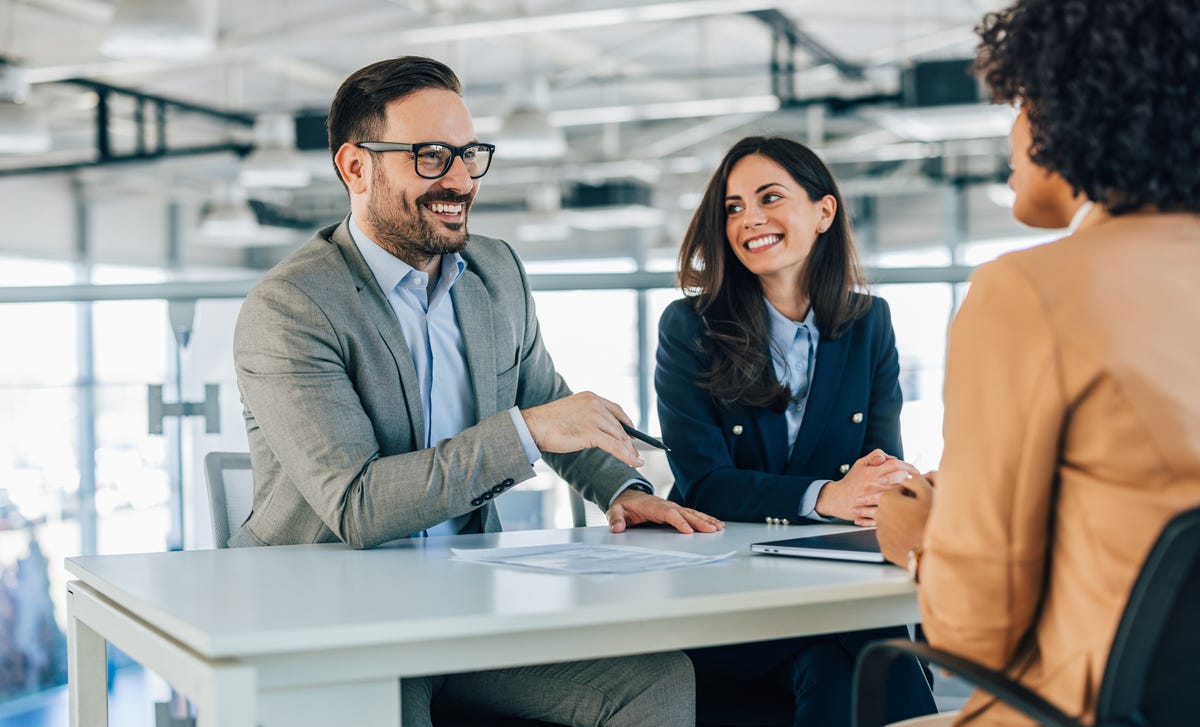 Des collègues parlent à un client en français des affaires qu'ils ont appris en suivant des formation francais professionnel
