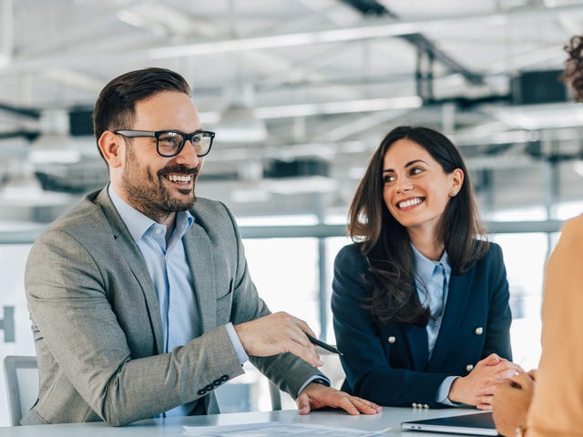 Des collègues parlent à un client en français des affaires qu'ils ont appris en suivant des formation francais professionnel