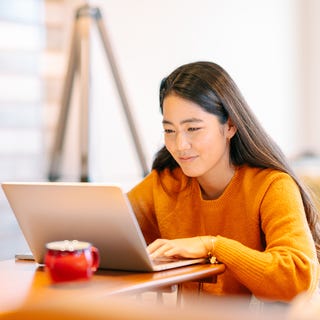 Woman sitting in front of a laptop and completing Berlitz's online placement test to find out her current language level
