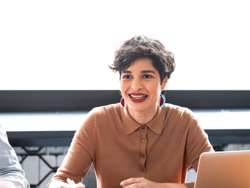 Femme avec un ordinateur portable et des notes autocollantes discutant avec son professeur de langue sur les mots interrogatifs en anglais